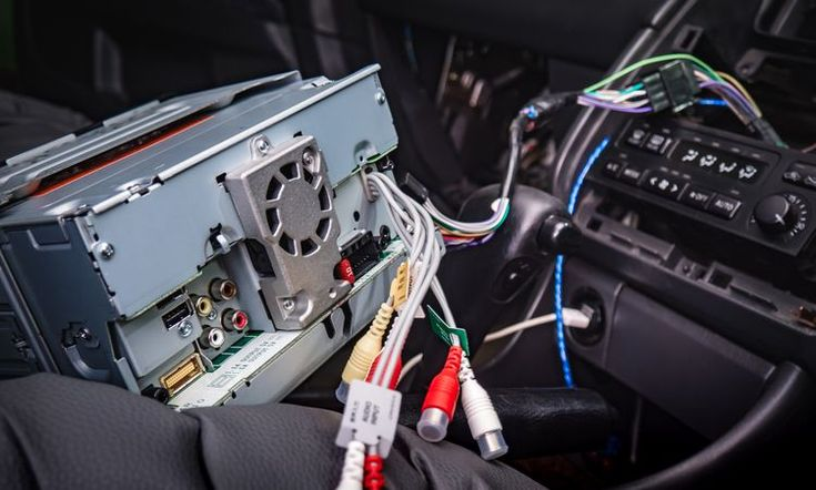 Plug-and-play car stereo wiring harness and CAN bus decoder connected to the factory electrical interface of a vehicle