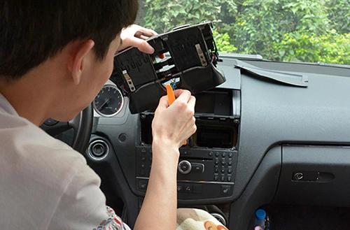 Removing the factory original car radio and dashboard trim panel before a vehicle-specific fascia fitment test