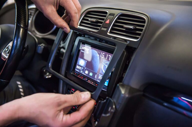 Test-fitting a model-specific car stereo dash kit and checking alignment accuracy before shipment