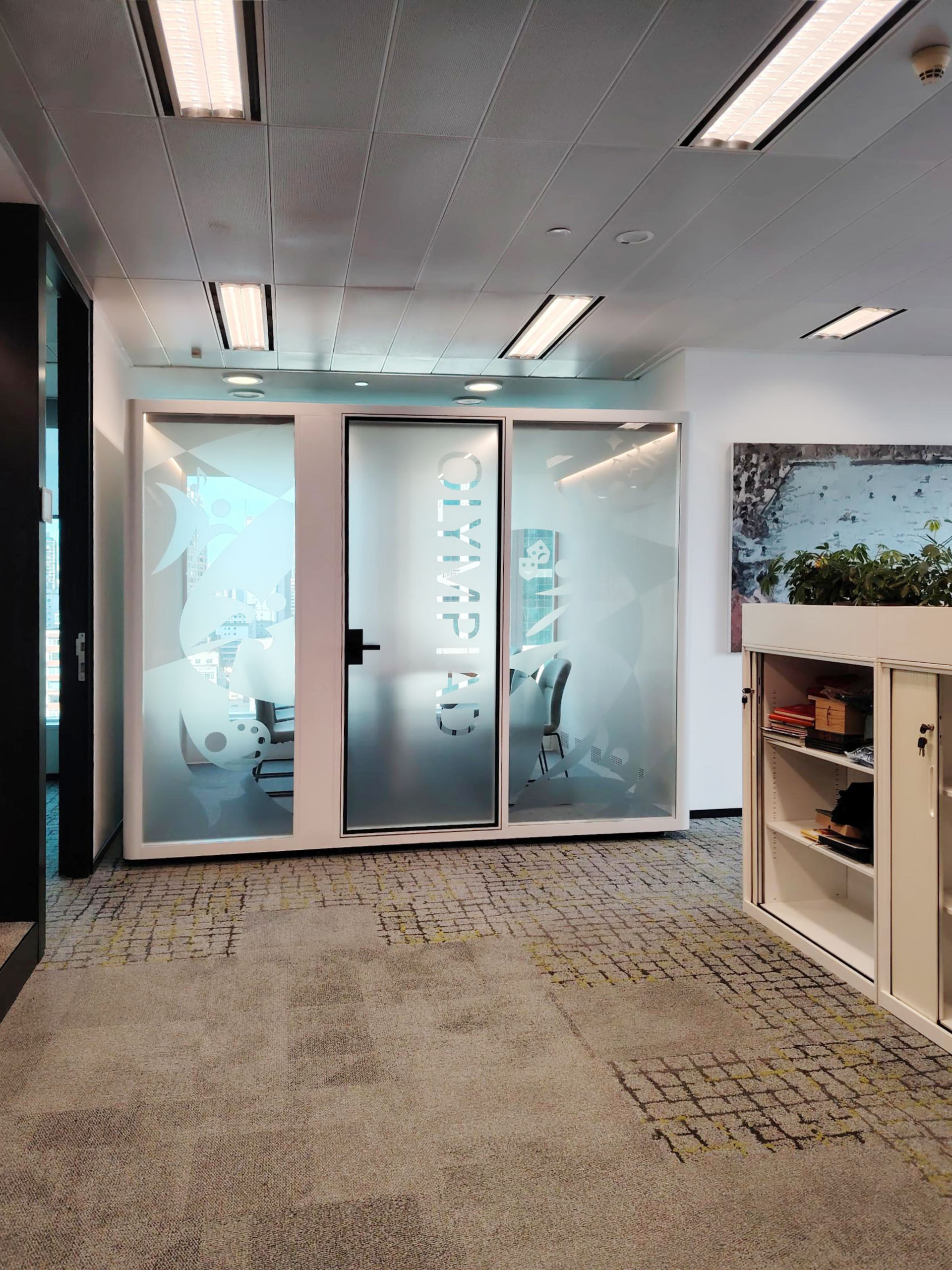 Multi-person acoustic pod used as a small conference room inside an open-plan office