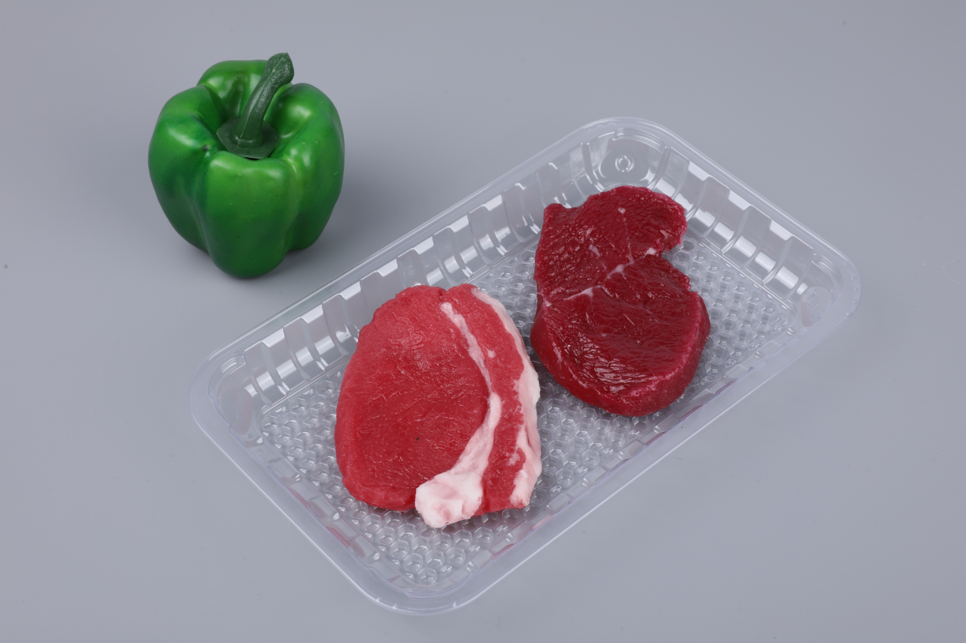 Moisture retention tray packed with fresh meat, showing purge collected below the product surface in the tray base