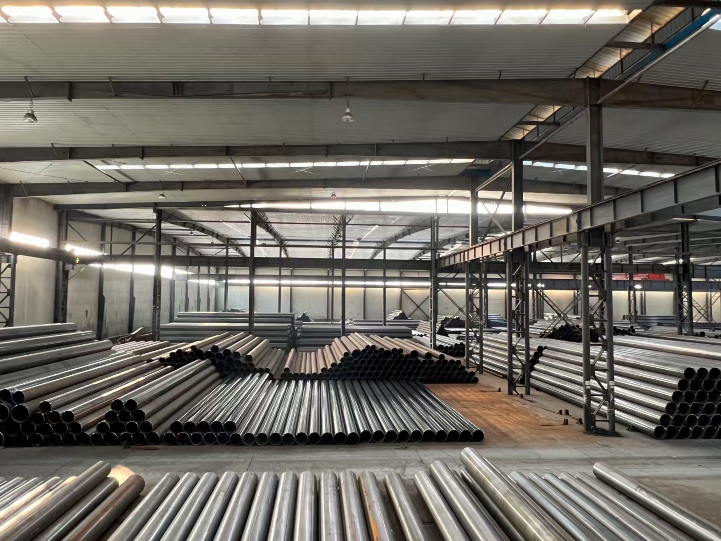 Steel pipe warehouse holding multiple pipe diameters and specifications ready for dispatch