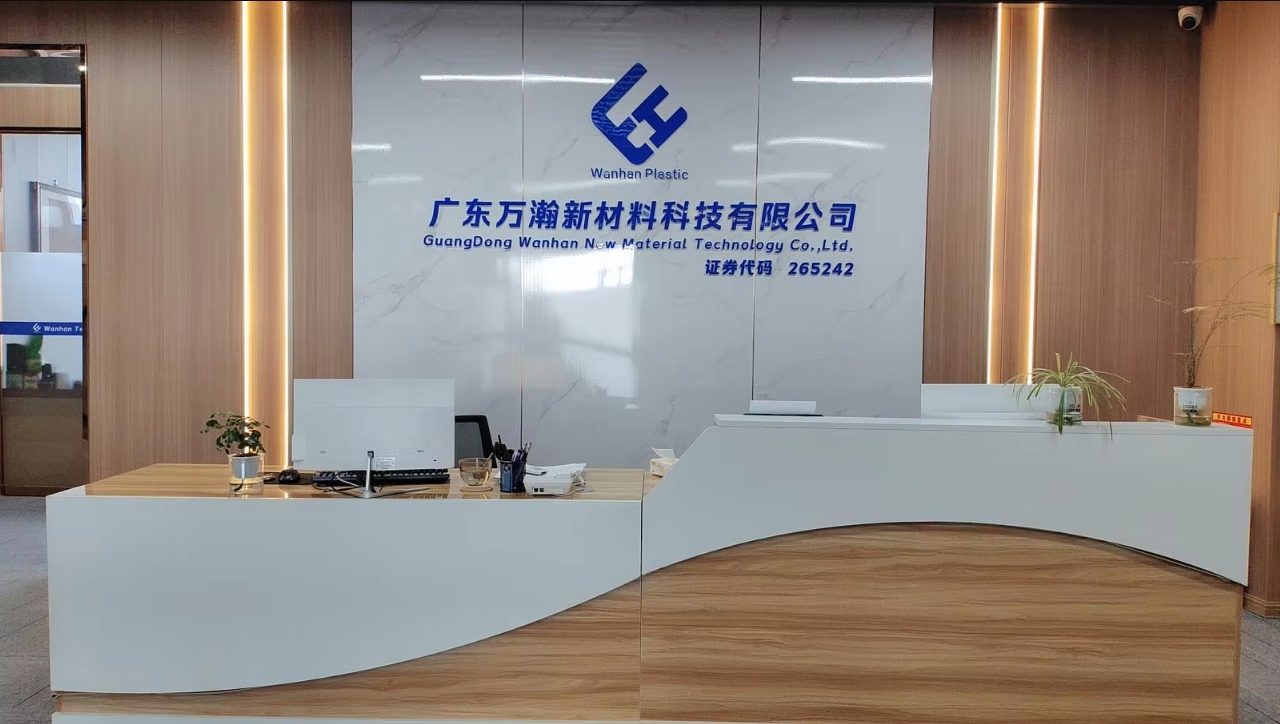 Reception area of Guangdong Wanhan New Material Technology Co., Ltd., with the WanHan Plastic name and brand displayed on the wall.