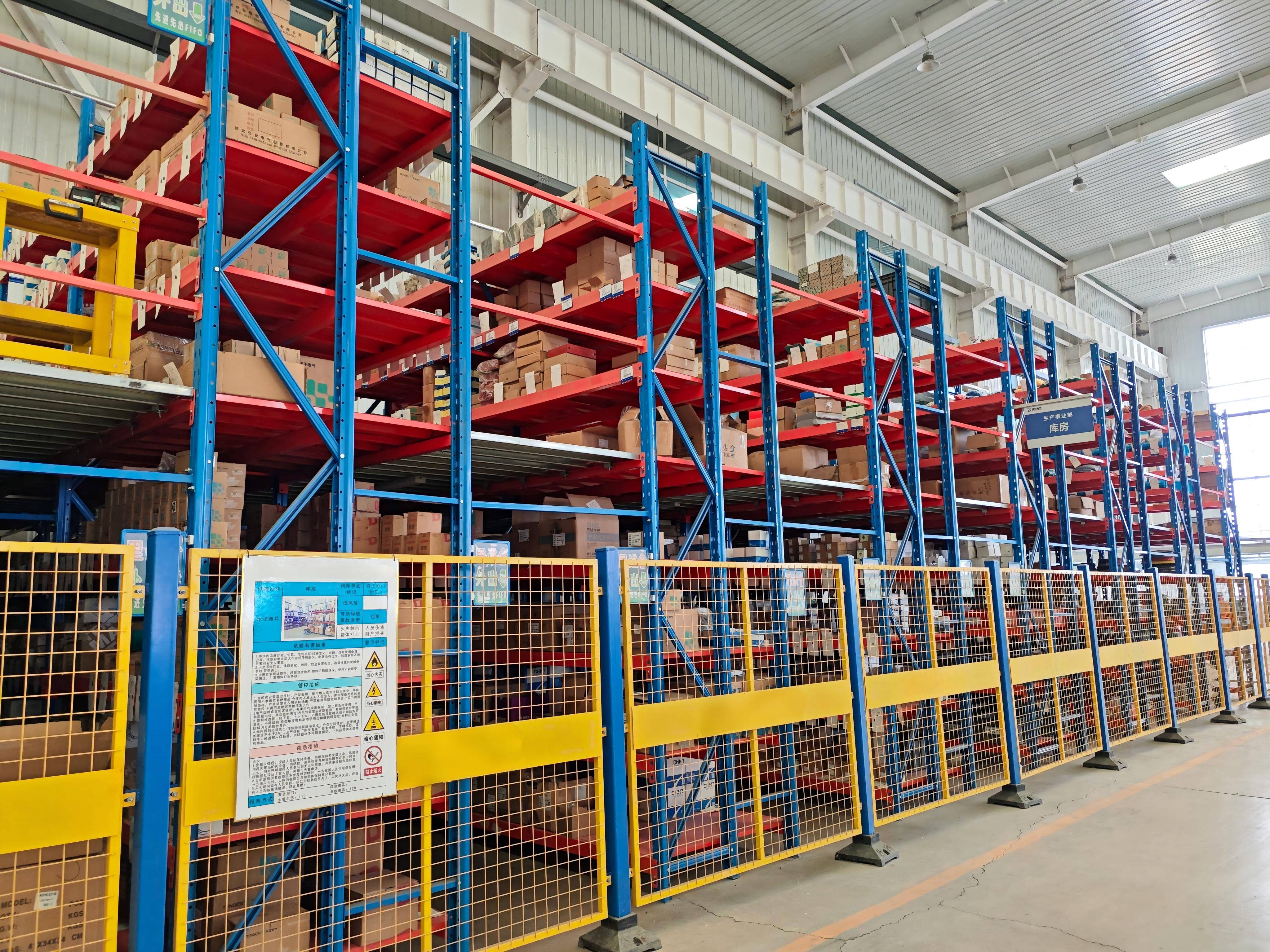 Raw material and component warehouse for transformer manufacturing, with materials arranged on designated storage racks. The warehouse holds production materials and electrical components used in transformer assembly and manufacturing.