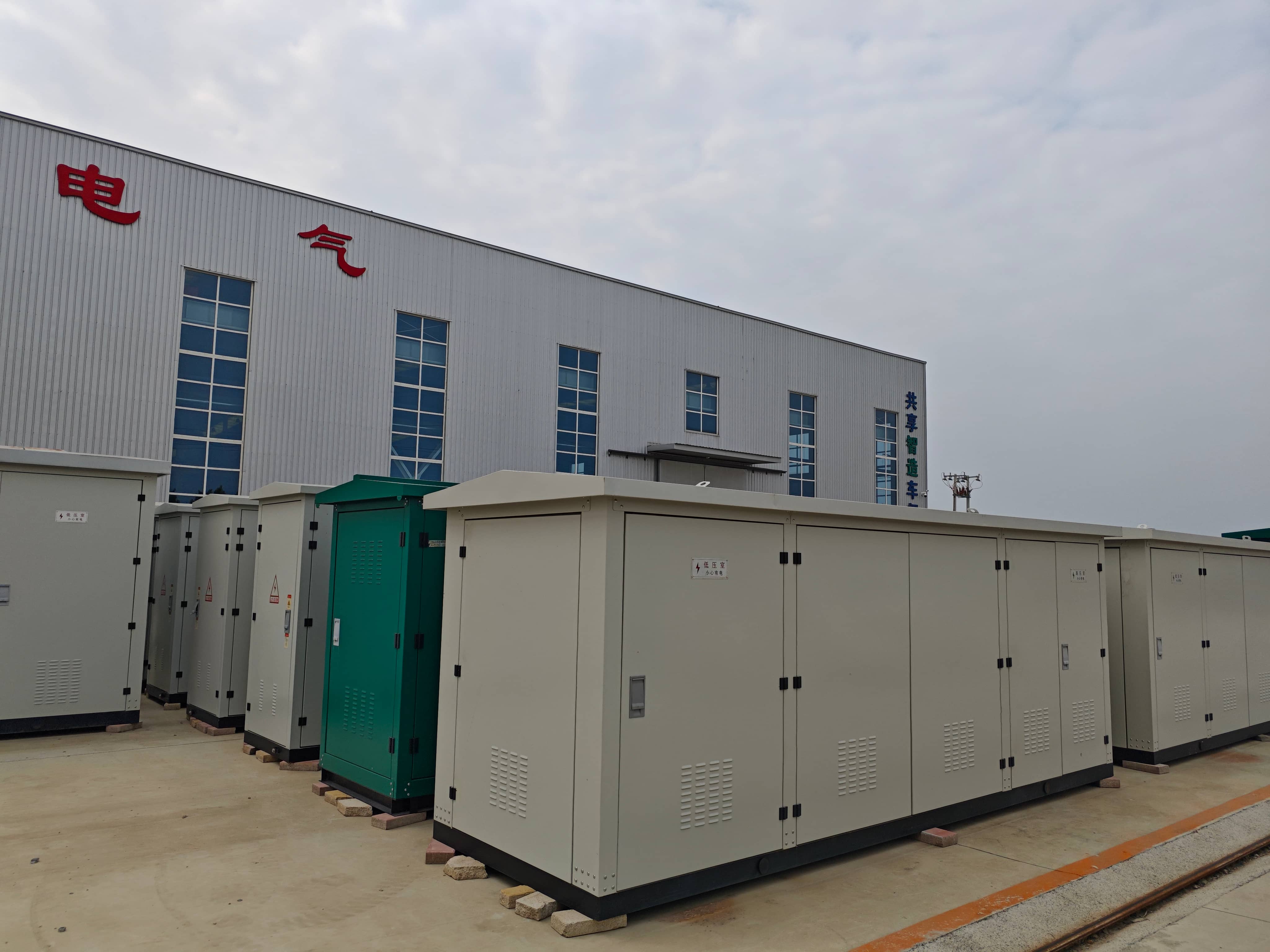 Outdoor storage yard at Milestone Electrical with completed prefabricated substations awaiting handling and shipment. These enclosed compact substation units are designed for electrical distribution applications, including industrial facilities, construction projects, utility networks, and outdoor power supply installations.